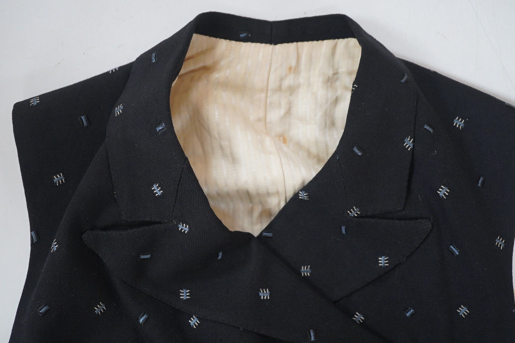 An Edwardian small gentleman’s double breasted waistcoat, made from black woven wool, with a sprig design, under arm chest 36inches. Condition - lining has various rust marks, the waistcoat would benefit dry cleaning